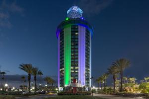 un alto edificio illuminato in verde e blu di Four Points by Sheraton Orlando International Drive a Orlando