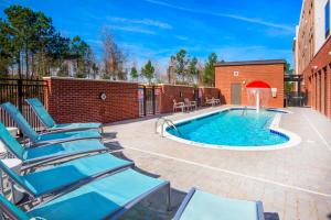 a patio with chairs and a swimming pool at SpringHill Suites by Marriott Wilmington Mayfaire in Wilmington