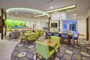 a restaurant with tables and chairs and a bar at SpringHill Suites by Marriott Wilmington Mayfaire in Wilmington