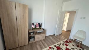 a living room with a television on a wooden cabinet at Apartment ADELINA in Tsarevo