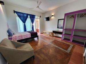 a bedroom with a bed and a chair and a mirror at Casa Puerto Bonito & Private Coworking in Puerto Escondido