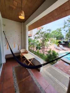 a porch with a hammock and a pool at Casa Puerto Bonito & Private Coworking in Puerto Escondido