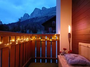 balcón con luces y vistas a la montaña en COSTALUNGAHOUSE TrekkingBikeSki selfcheck-in apartment en Carezza al Lago