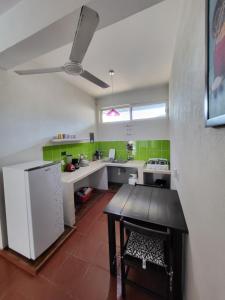 a kitchen with a table and a white refrigerator at Casa Puerto Bonito & Private Coworking in Puerto Escondido