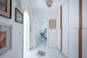 a hallway of a home with white walls and an archway at Villa Domenicanda in Capri +50 photos