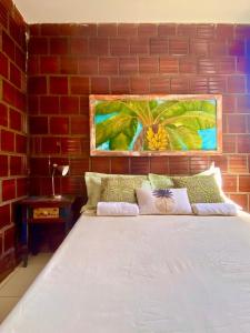 uma cama num quarto com uma parede de tijolos em Chalé Capixaba em Gravatá
