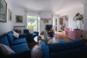 a living room with blue couches and a glass table at Villa Domenicanda in Capri