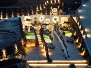 una vista aerea di una casa con piscina di notte di Theano Cave Suites & Villas a Imerovigli