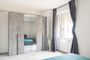 1 dormitorio con espejo grande frente a la cama en Almi - Guest Apartment, en Porto Torres