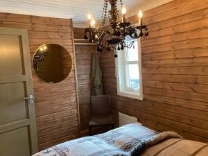 a bedroom with wooden walls and a chandelier at Bo lunt og koselig på Filefjell in Tyinkrysset