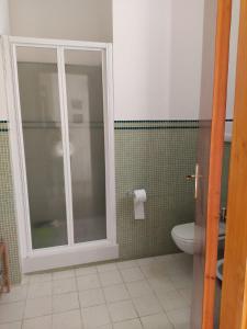 uma casa de banho com um WC e uma porta de vidro em Vivere il mare em Palinuro