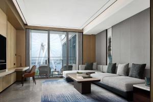 uma sala de estar com um sofá e uma mesa em JW Marriott Hotel Shenzhen Bao'an International Airport em Bao'an