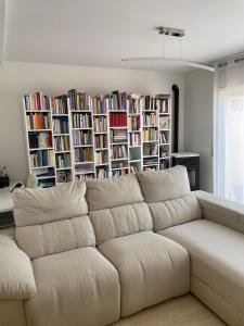 a white couch in a living room with bookshelves at Empordà Country House in Borrassá