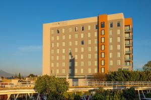 un edificio alto con un puente delante de él en Four Points by Sheraton Puebla, en Puebla