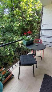 een tafel en een stoel op een balkon met bloemen bij Apartman Sonja in Lovran