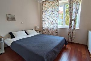 een slaapkamer met een bed en een raam bij Apartman Sonja in Lovran