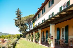 un bâtiment avec des tables et des chaises dans une cour dans l'établissement Relais Farinati - Adults only, à Lucques