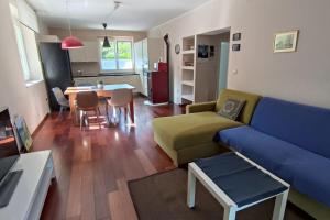 een woonkamer met een blauwe bank en een tafel bij Apartman Sonja in Lovran