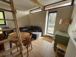 a living room with a couch and a table at Gite lumineux et confortable - La ferme de Montigny in Neauphe-sur-Dives