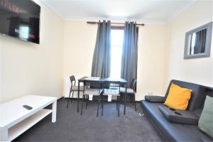 a living room with a couch and a table at Lovely 3bedroom Apartment London in London