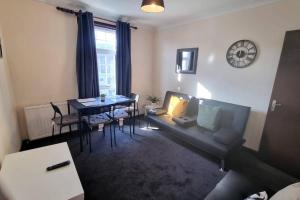 ein Wohnzimmer mit einem Sofa und einem Tisch in der Unterkunft Lovely 3bedroom Apartment London in London