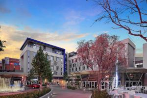 a building with a fountain in the middle of a street at Protea Hotel by Marriott Pretoria Loftus Park in Pretoria