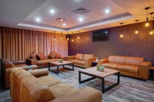 una gran sala de estar con sofás y TV de pantalla plana. en Protea Hotel by Marriott Pretoria Loftus Park, en Pretoria