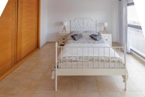 a bedroom with a white bed and a tiled floor at Casa Castillo in Costa de Antigua