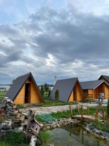 a couple of buildings with a pond in front of them at BRVNARE.SMAKA in Sjenica