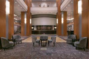 un hall avec des chaises et des tables dans un bâtiment dans l'établissement Sheraton Bucharest Hotel, à Bucarest