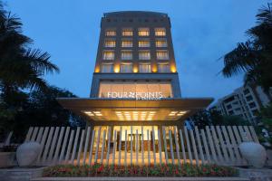 Four Points by Sheraton Bengaluru Whitefield في بانغالور: مبنى الفندق عليه لافته
