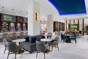 a lobby with tables and chairs and a bar at Orlando Marriott Lake Mary in Lake Mary
