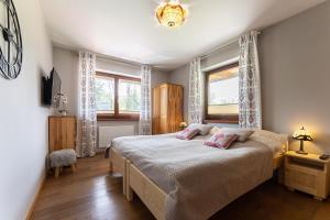 - une chambre avec un lit et 2 fenêtres dans l'établissement Apartament Sobiczkowa Zakopane, à Kościelisko