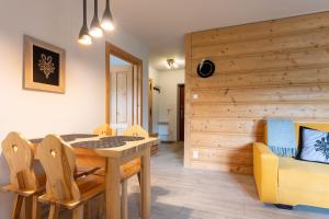 - une salle à manger avec une table et un canapé dans l'établissement Apartament Sobiczkowa Zakopane, à Kościelisko