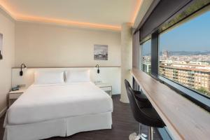 ein Hotelzimmer mit einem Bett und einem großen Fenster in der Unterkunft Four Points by Sheraton Barcelona Diagonal in Barcelona