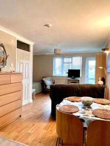 uma sala de estar com um sofá e uma mesa em Sandford House Apartment em Seaford