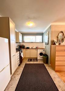 een keuken met witte kasten en een zwart tapijt bij Sandford House Apartment in Seaford