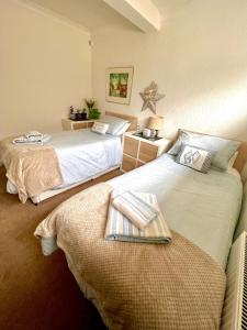 two beds sitting next to each other in a room at Sandford House Apartment in Seaford