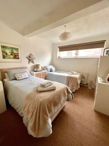 a bedroom with two beds and a window at Sandford House Apartment in Seaford