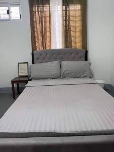 a large bed in a bedroom with a window at Sidra Ville Apartment in Balanga