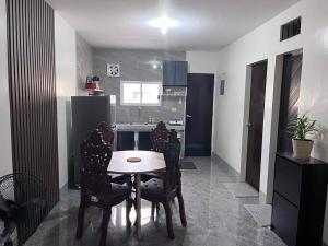 a kitchen with a table and chairs in a room at Sidra Ville Apartment in Balanga
