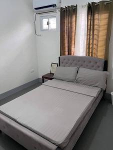 a large bed in a bedroom with a window at Sidra Ville Apartment in Balanga