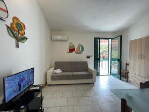 ein Wohnzimmer mit einem Sofa und einem Flachbild-TV in der Unterkunft Appartamenti magnolie-La pineta in Valledoria