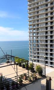 a view of a large apartment building and the ocean at Blue Apartment in Gonio