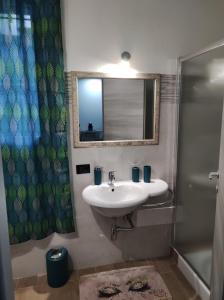 a bathroom with a sink and a mirror and a shower at A casa di Lina in Olbia