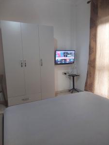 una camera con letto, armadio e TV di GreenVilla Park a Durrës