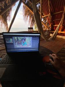 a person sitting in a hammock with a laptop computer at Frente al Mar in Dibulla