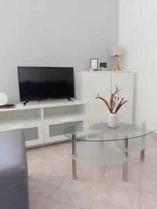 a living room with a glass table and a tv at MARTINA 2 in Bašanija