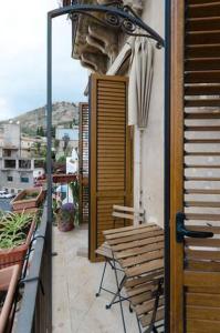 un balcone con sedie e ombrellone su un edificio di Appartamento "La Scala" a Taormina