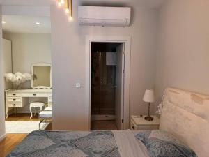 1 dormitorio con cama, escritorio y espejo en Kordon İstanbul Luxury House 3+1, en Estambul